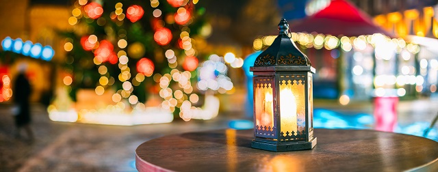 Christmas Lantern With Burning Candle On Bright Blurred Christmas Xmas Lights Background.